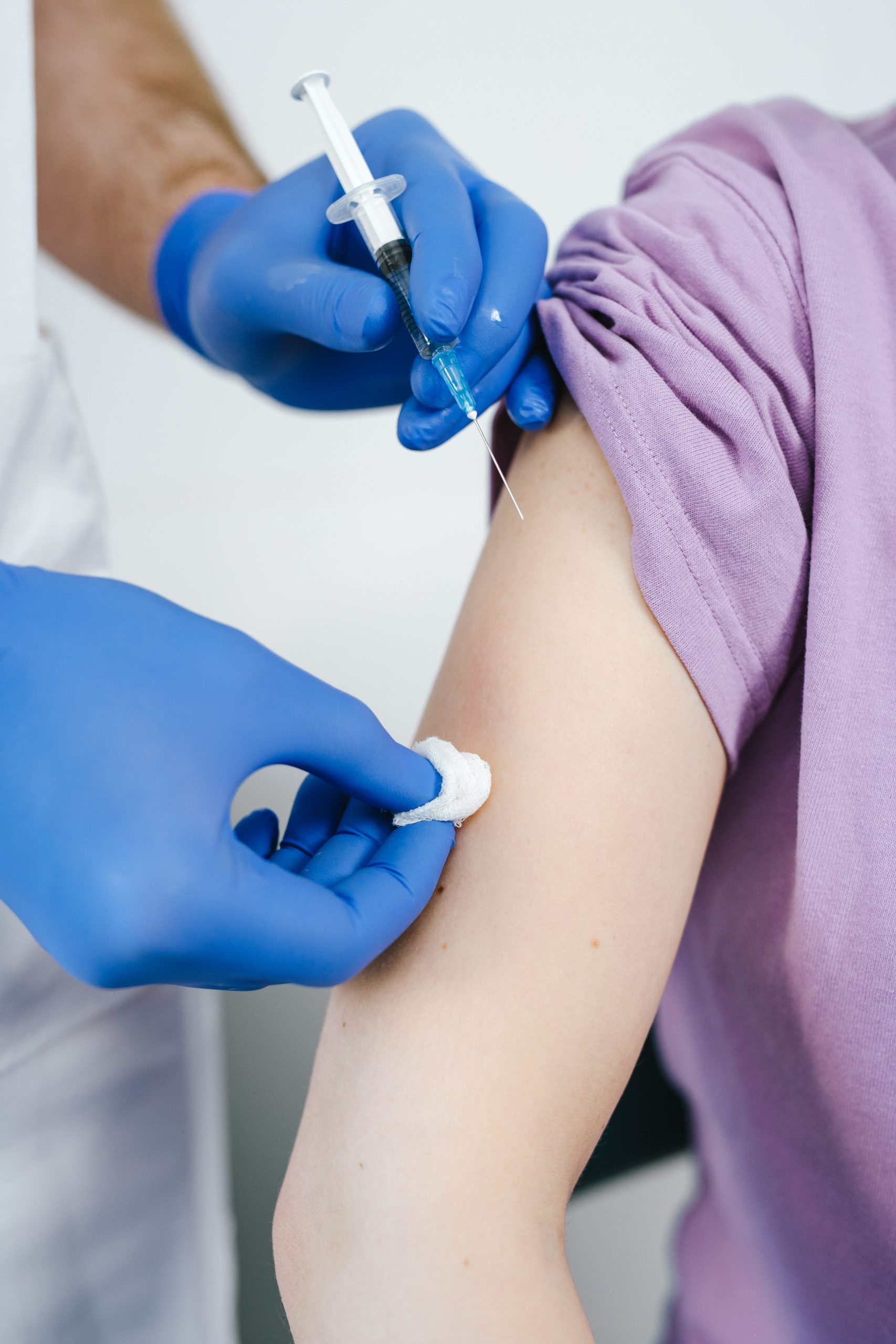 Close-up of a medical professional giving a vaccine shot in a patient's arm.